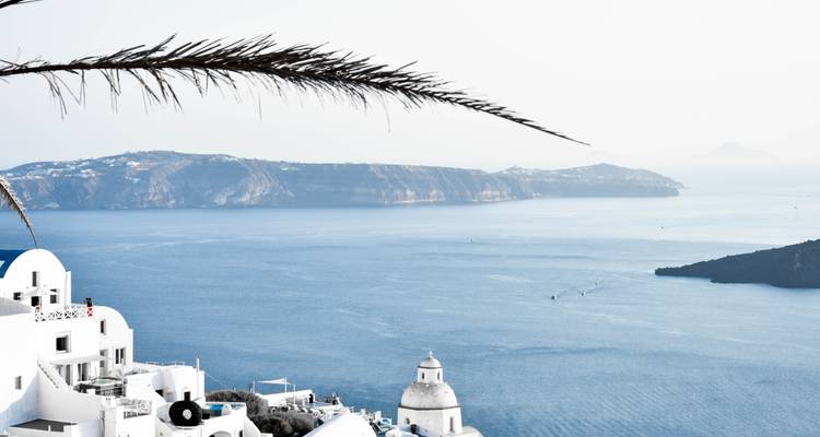 Minimalistische caldeira-uitzicht vanaf Santorini met witte architectuur en verre eilanden.
