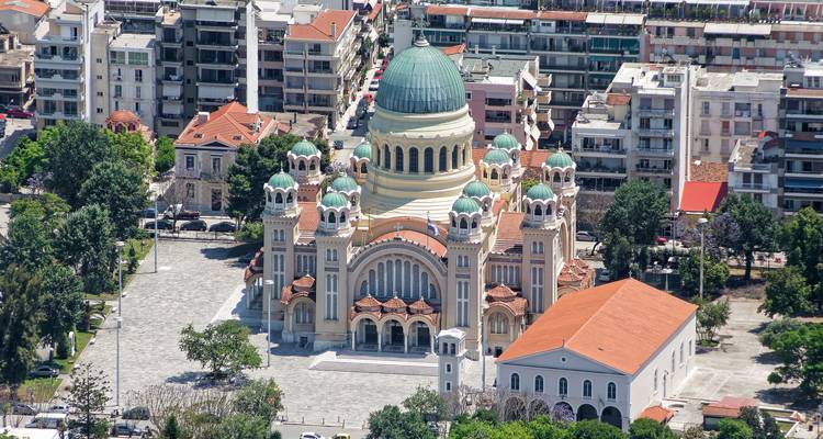 Elevated view of grand domed Saint Andrew Cathedral surrounded by modern Patras city blocks.