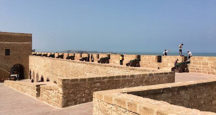 Visitors explore the sun-baked stone ramparts and cannons of Essaouira’s sea fort overlooking the Atlantic.