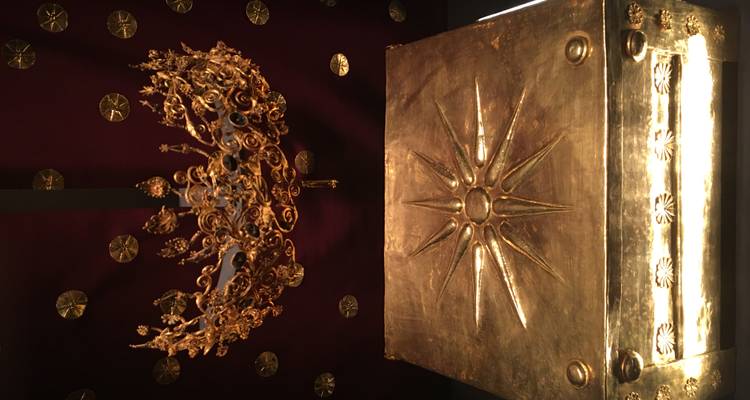 Prachtige antieke gouden wreathkroon die zwevend boven een sierlijke gouden kist wordt getoond, gegraveerd met de Macedonische zon.