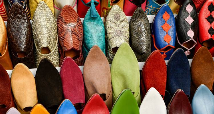 Filas ordenadas de coloridas pantuflas de cuero marroquíes tradicionales.