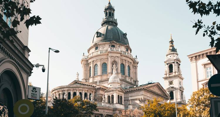 Elegant facade and dome of St. Stephen's Basilica framed by autumn trees