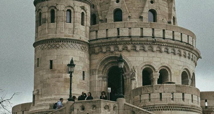 Visitors gathered at the ornate stone towers of Fisherman's Bastion under grey sky
