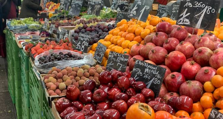Exhibición colorida de frutas y bayas en un mercado al aire libre de Viena con etiquetas de precios escritas a mano.