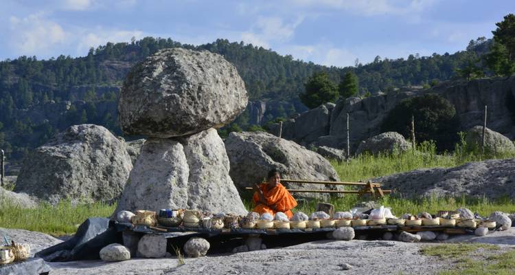 Femme tarahumara vendant des paniers faits à la main exposés sur une bâche parmi des rochers de forme de champignon géant