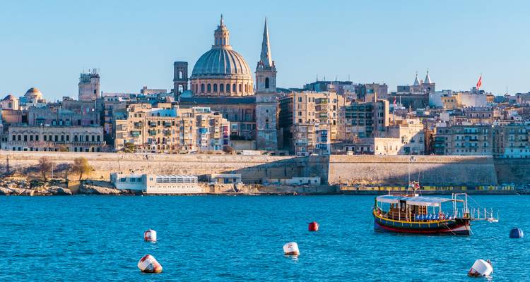 Uitzicht over de blauwe Grand Harbour naar de skyline van Valletta met daarop de koepel van de kathedraal van Sint Paulus