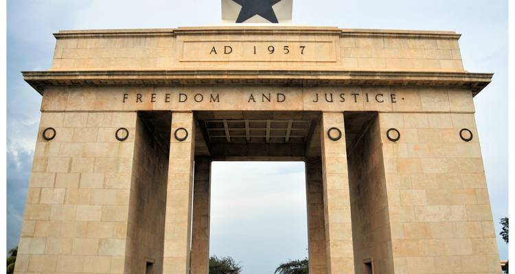 L'Arc de l'Indépendance d'Accra portant l'Étoile noire et l'inscription « Liberté et Justice » sur un ciel pâle.