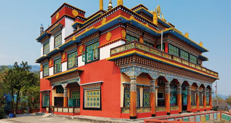 Brightly painted Tibetan monastery with ornate window frames set against a clear sky
