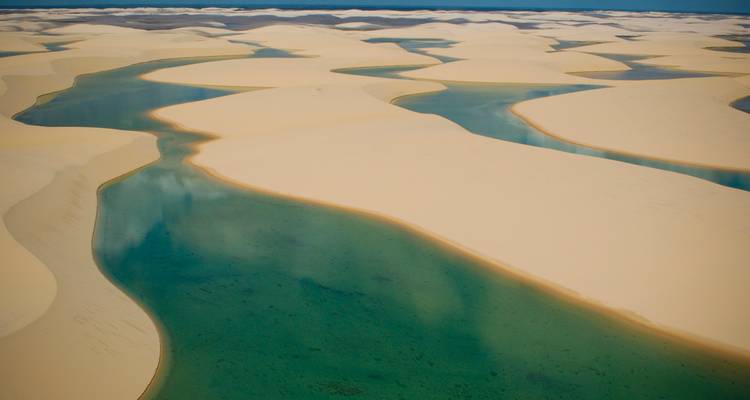 Aerial view of turquoise lagoons winding through cream-coloured dunes of Lençóis Maranhenses