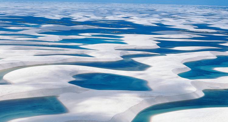 Sweeping aerial panorama of countless blue lagoons and white dunes stretching to the horizon
