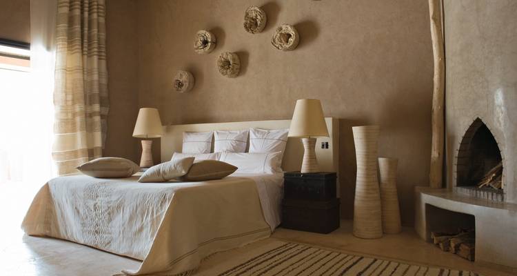 Stylish desert-tone bedroom with fireplace and natural décor.