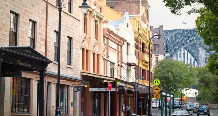 Charmante historische Straße im Stadtteil The Rocks mit Blick auf die Sydney Harbour Bridge in der Ferne.