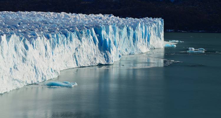 Een dramatische bevroren klif van de Perito Moreno-gletsjer daalt af naar stil turquoise water.