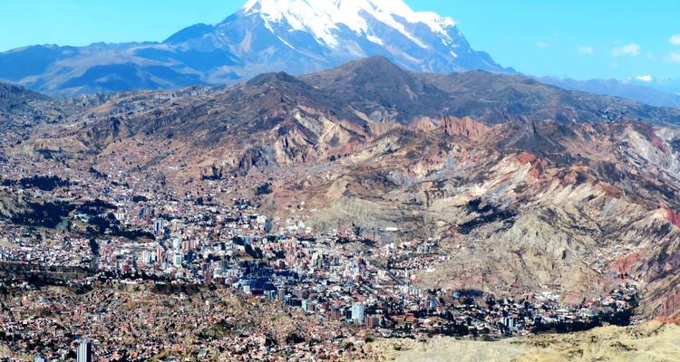 La Paz strekt zich uit over een robuust dal onder de met sneeuw bedekte berg Illimani.