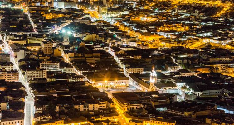 Uitgestrekte verlichte stadsgezicht 's nachts met gloeiend straatpatroon en historische gebouwen van bovenaf gezien.