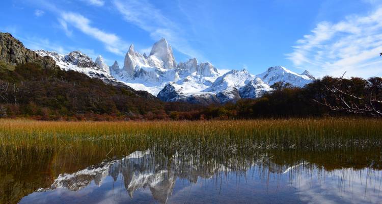 Los icónicos picos dentados del Monte Fitz Roy reflejados perfectamente en una laguna de otoño tranquila.