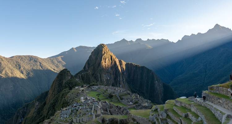 Vista panorámica clásica de las ruinas de Machu Picchu con el pico Huayna Picchu iluminado por los rayos de la mañana.