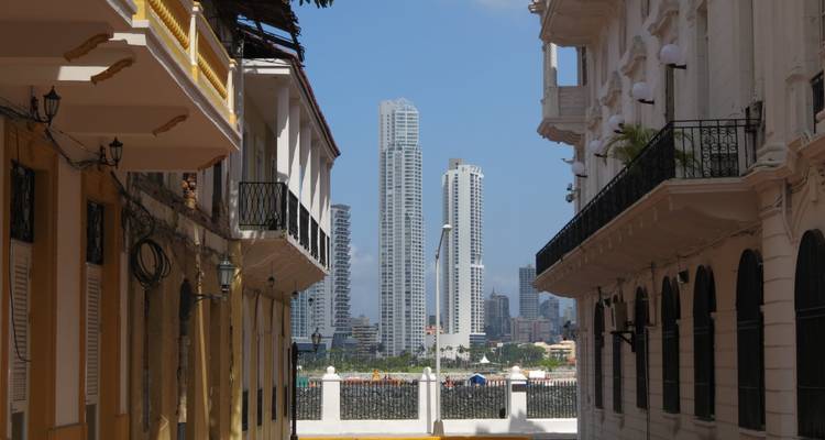 Historische Kolonialstraße, die entfernte moderne Hochhäuser von Panama City unter klarem blauen Himmel rahmt.