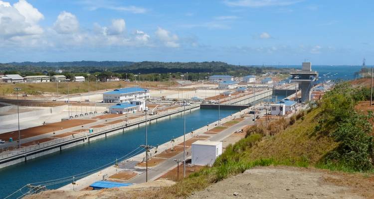 Panoramablick auf das neue Panamakanal-Schleusensystem, das sich landeinwärts erstreckt, mit türkisfarbenem Wasserkanal.