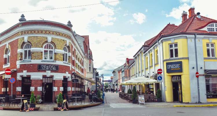 Charmante Europese straathoek met kleurrijke historische gebouwen, cafés en voetgangers onder een heldere hemel
