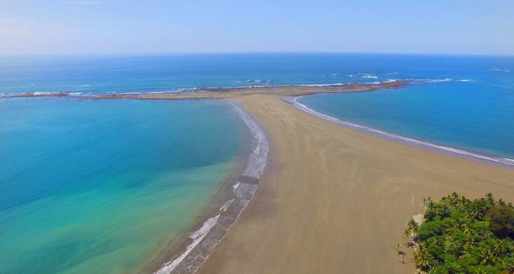 Vista aérea de la barra de arena con forma de cola de ballena encontrándose con el océano turquesa