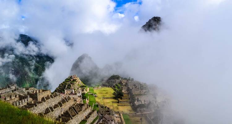 Ikonische Ruinen von Machu Picchu, die sich durch wirbelnden Bergnebel abzeichnen