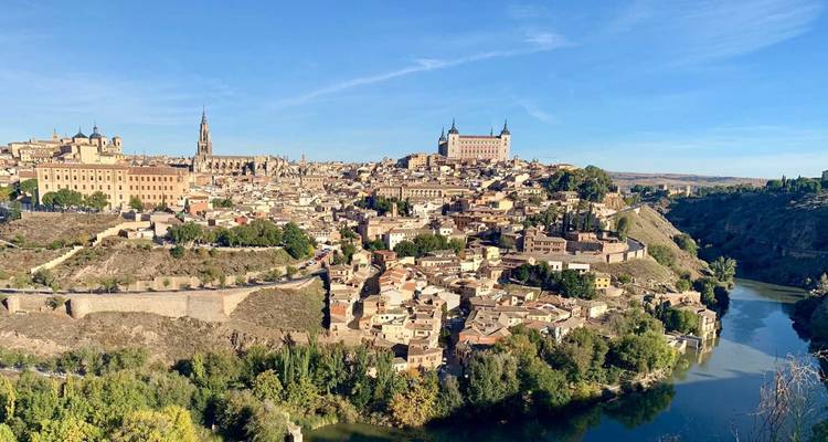 Panoramic view of Toledo's historic hilltop city with cathedral spire and Alcázar overlooking the Tagus River valley.