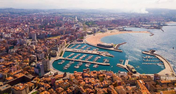 Aerial view of Gijón with its marina, sweeping bay and urban skyline framed by hills.