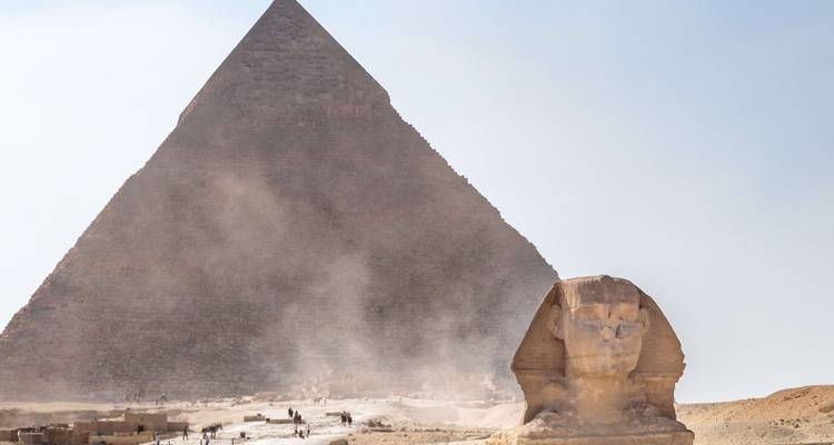 Le Grand Sphinx se dresse face à la Grande Pyramide enveloppée de poussière sur le plateau de Giza.