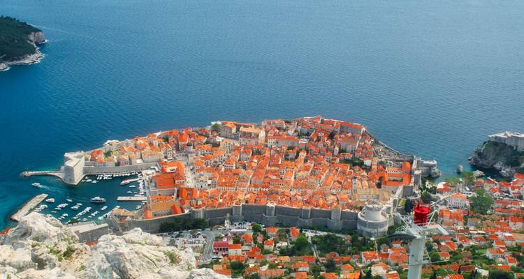 Point de vue élevé surplombant la vieille ville compacte de Dubrovnik aux toits orange qui s'avance dans la mer