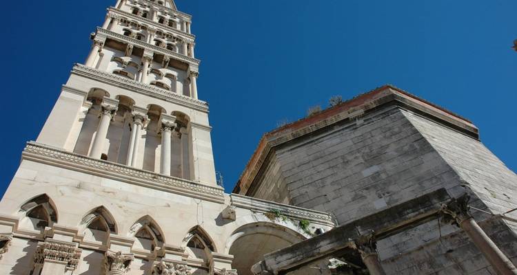 Vue de bas en haut du clocher en pierre pâle de la Cathédrale Saint-Domnius de Split sur un ciel bleu éclatant