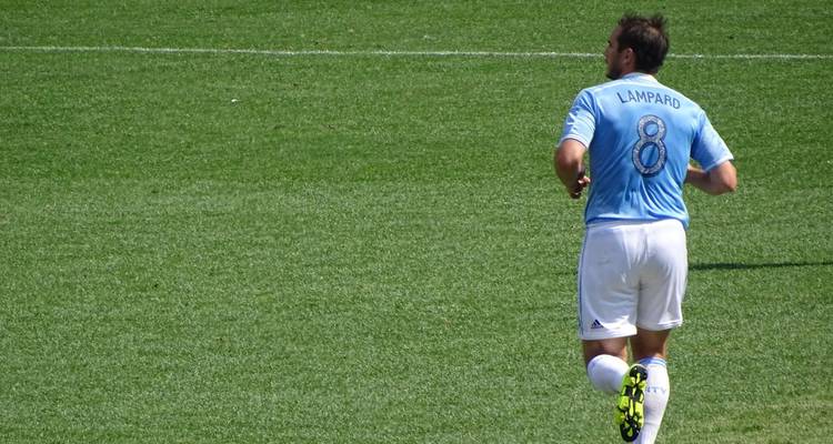 Voetballer in een lichtblauwe shirt met nummer 8 die op het veld aan het joggen is