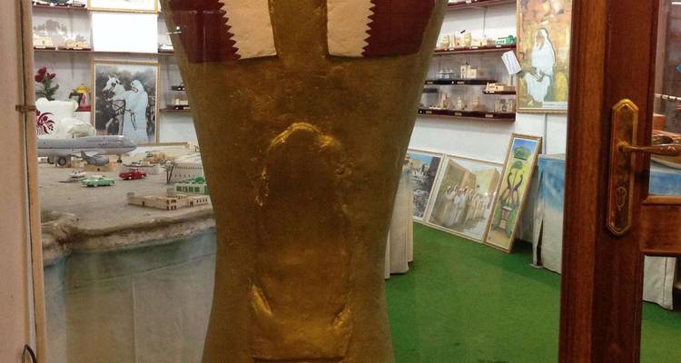 Grote gouden replica van de Wereldbeker trofee tentoongesteld in een klein tentoonstelling met Qatarese vlaggen