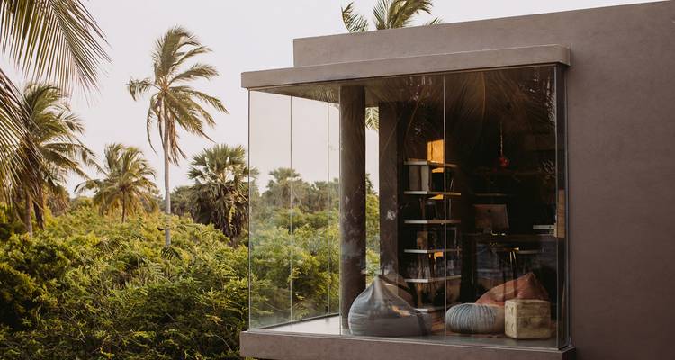 Moderne jungle lodge met glazen wanden met uitzicht op weelderig tropisch groen.