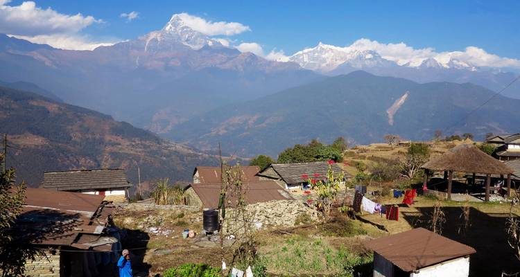Bergdorp met stenen huizen en terrasvormige velden met uitzicht op het Annapurna-gebergte