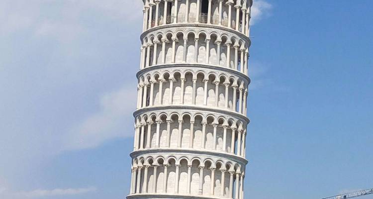 Iconische Scheve Toren van Pisa die scheef staat tegen een helderblauwe lucht.