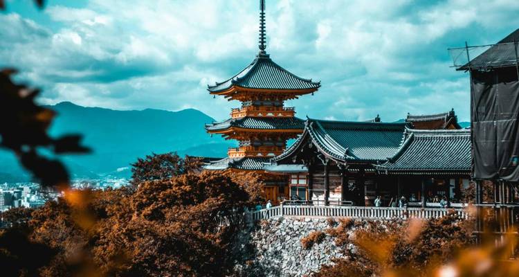 Pagode von Kiyomizu-dera auf einem bewaldeten Hang unter dramatischem Wolkenhimmel