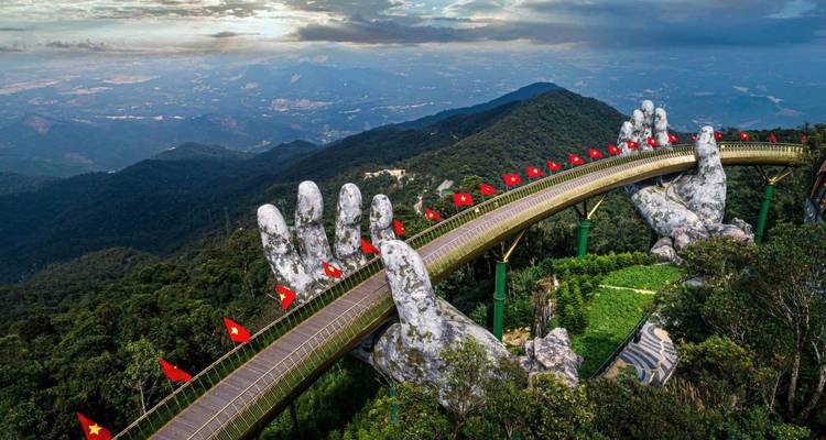 Die ikonische Goldene Brücke, gestützt von riesigen Steinhänden, erstreckt sich über üppige Berge in der Nähe von Da Nang.