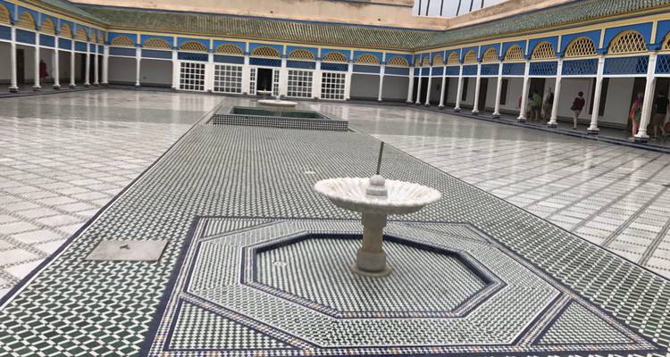 Patio grande con azulejos y fuente central dentro de un palacio marroquí histórico