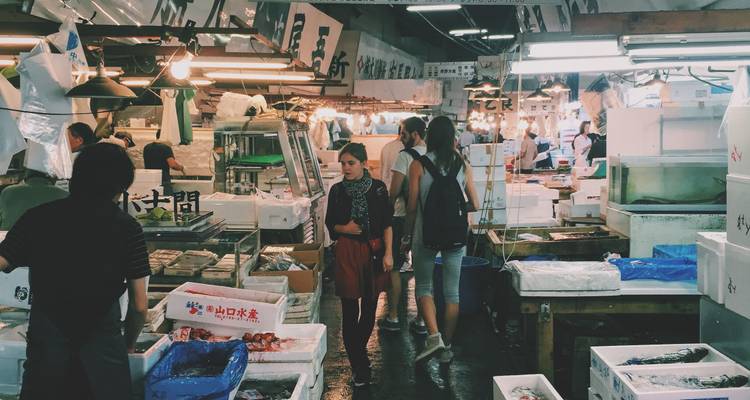 Geschäftiges Inneres des Fischmarktes von Tokio mit Einheimischen und Touristen, die zwischen frischen Fischständen spazieren