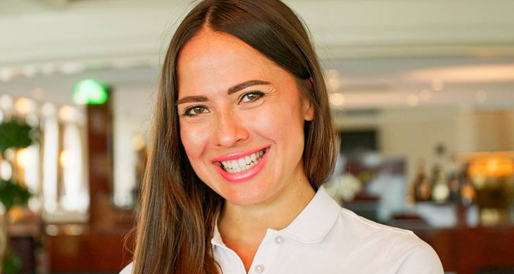 Retrato de cerca con sonrisa de un miembro del personal de HolidayMax en interiores.