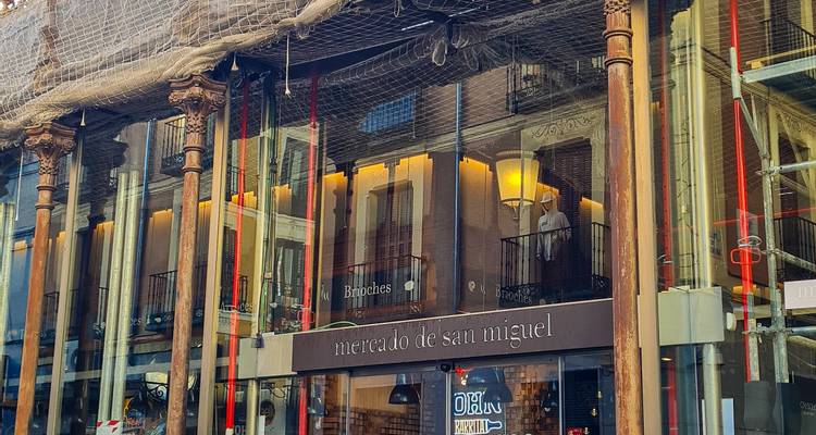 Vue de la rue du Mercado de San Miguel, extérieur avec murs en verre et colonnes en fer forgé.