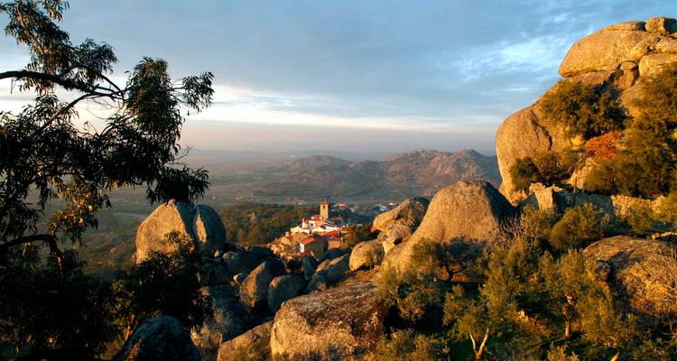 Vista panorámica desde las rocas de granito sobre el pueblo de tejados rojos de Monsanto al amanecer