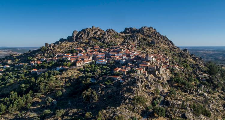 Panorama aéreo del pueblo de Monsanto agarrado a un pico de granito en medio de llanuras extensas