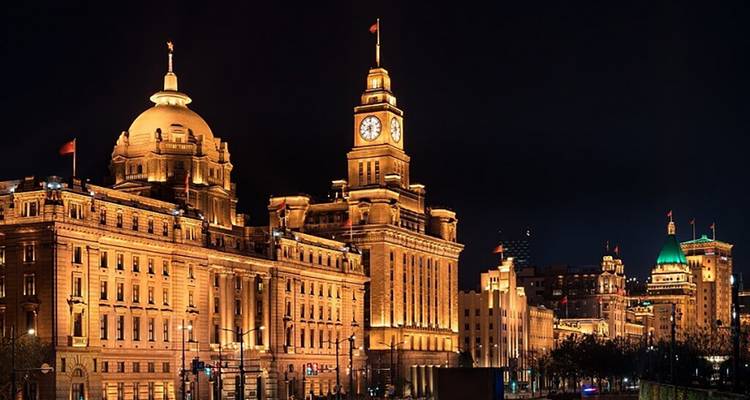 Vue nocturne du Bund de Shanghai avec l'architecture historique illuminée.