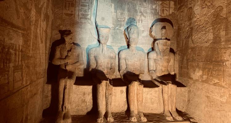 Les statues assises faiblement illuminées à l'intérieur d'Abu Simbel révèlent l'art ancien et les reliefs peints.