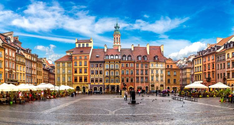Vista panorámica de la Plaza del Mercado de la Ciudad Vieja de Varsovia con edificios coloridos y cafés al aire libre.