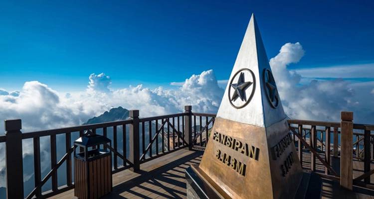 Ikonischer Obelisk des Fansipan-Gipfels über einem wolkengefüllten Bergpanorama.