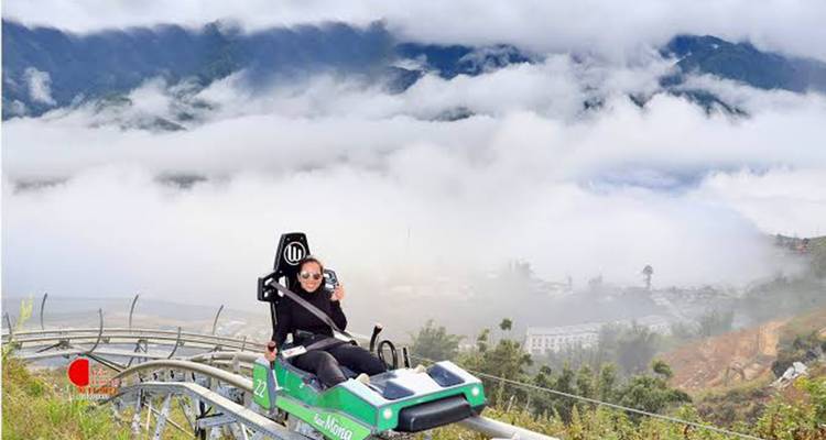Ein einzelner Fahrer auf der Bergachterbahn, der durch Wolken und nebelhafte Talaussichten hinabfährt.