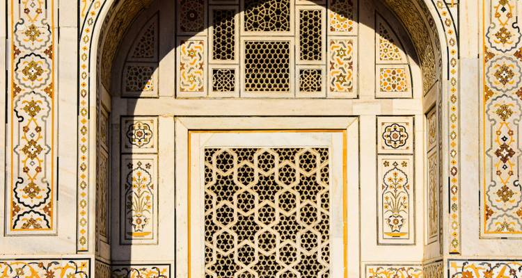 Nahaufnahme der kunstvollen Pietra-Dura-Gitterwerk und geometrischen Einlegearbeiten an der Mughal-Marmorfassade.